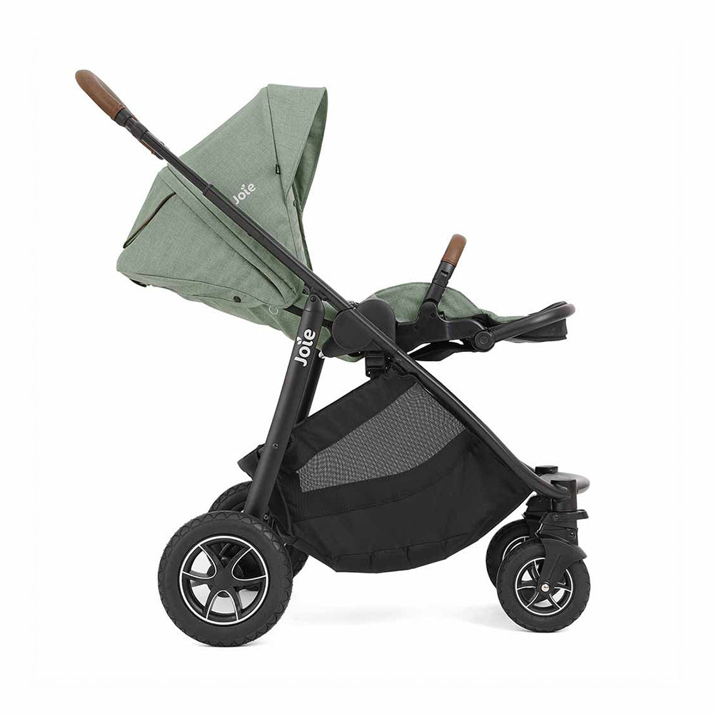 Carrinho de passeio Joie Versatrax™ cinzento, com assento virado para a frente, mostrando as rodas robustas e o guiador ajustável.