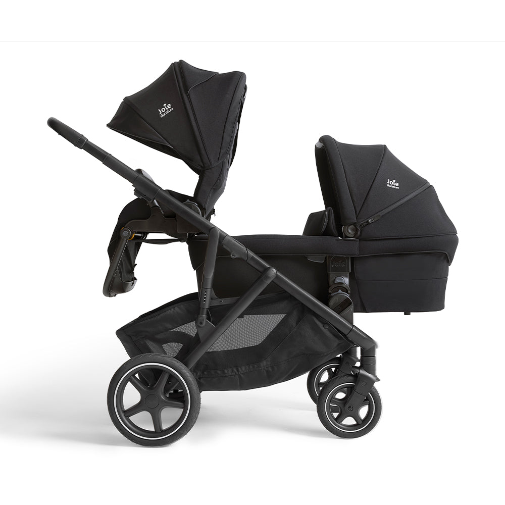 Carrinho tandem Joie Versiti Signature preto com um assento principal virado para a frente e uma alcofa Ramble XL na posição de gémeos.