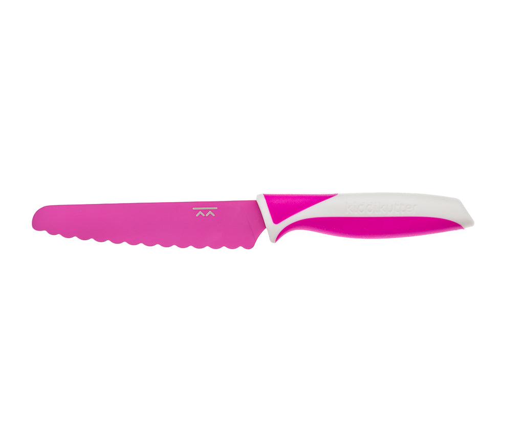 Faca KiddiKutter cor-de-rosa vibrante com lâmina de serra arredondada e pega ergonómica branca, ideal para autonomia na cozinha infantil.