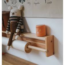 KidyWolf Coluna de Som Bluetooth cor de terracota numa prateleira, integrada na decoração de um quarto infantil.