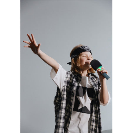 Criança com bandana a cantar com entusiasmo num microfone KidyWolf, com o braço estendido num gesto de performance.