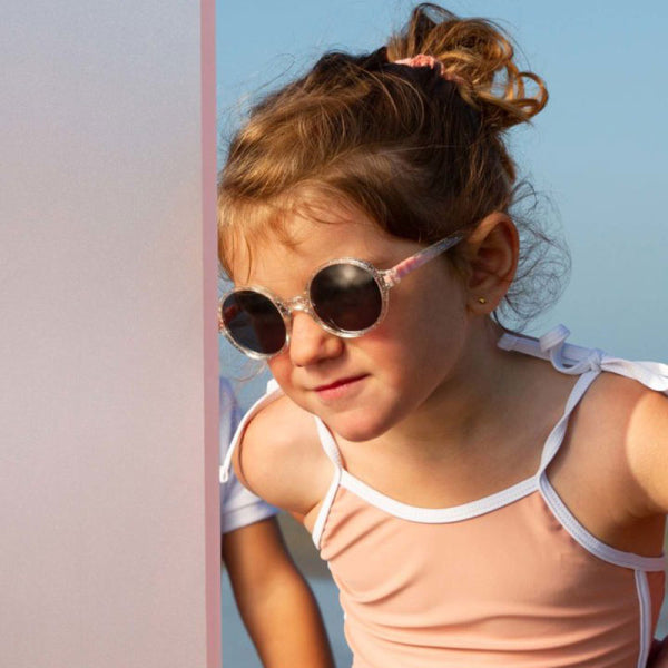 Óculos de sol Kietla RoZZ Glitter para crianças de 4 a 6 anos. Armação transparente com glitter e lentes escuras redondas.