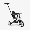 Triciclo evolutivo Kikkaboo FLIP 5 em 1 em cor bege/creme, com assento preto e guiador parental removível, isolado em fundo branco.