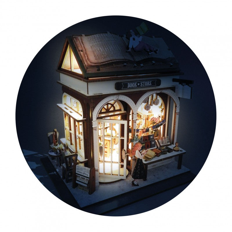 Diorama da livraria montado, iluminado com luzes LED no interior, criando um ambiente noturno acolhedor.