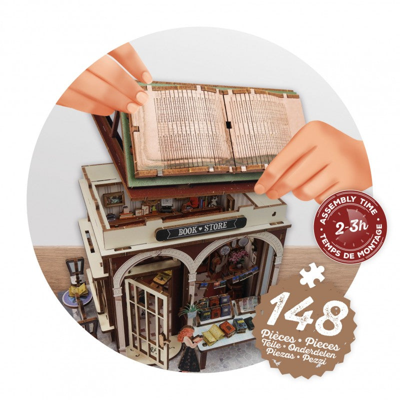 Mãos a encaixar a secção superior do diorama da livraria, destacando o contador de tempo de montagem de 2-3 horas e as 148 peças.