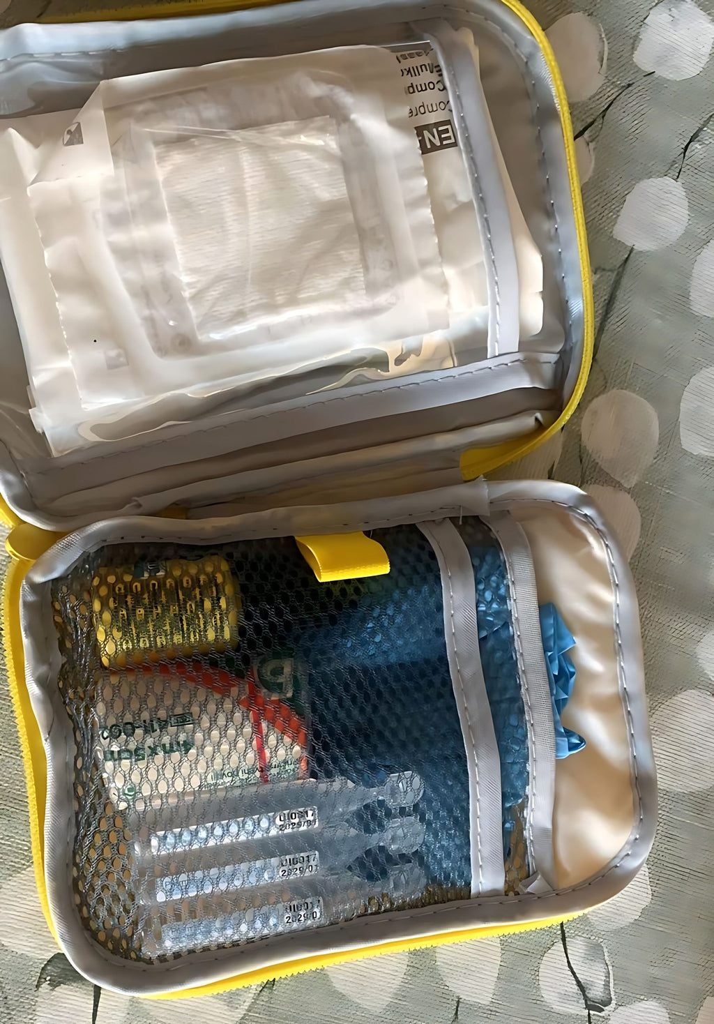 Kit de primeiros socorros Gotu aberto, com compressas, luvas, soro fisiológico em unidoses e ligadura arrumados