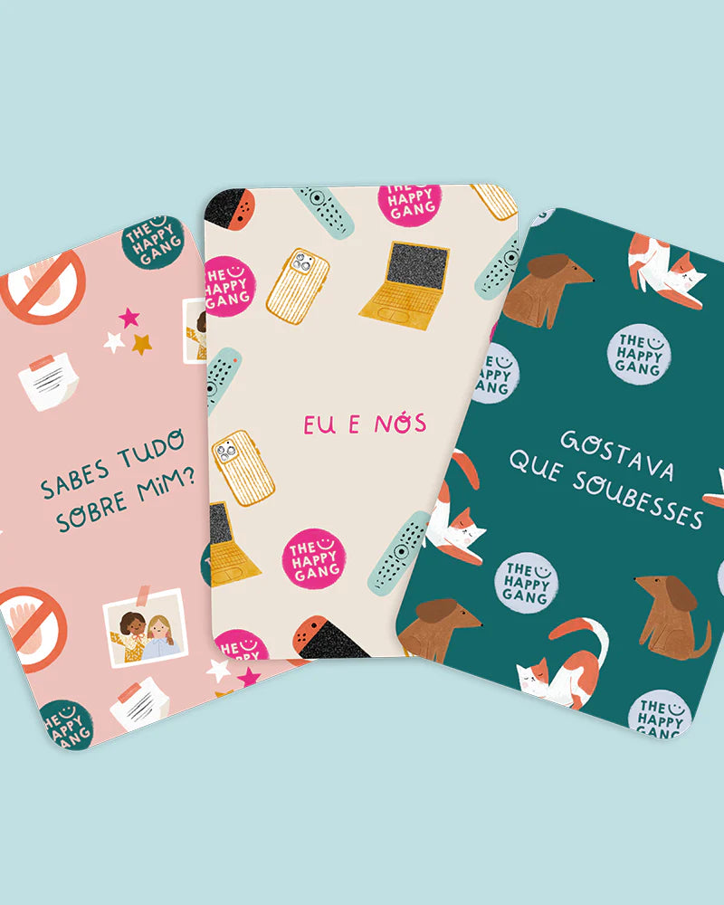 Três baralhos de cartas do jogo "Conversas Pais vs Filhos" com diferentes padrões e o logótipo "The Happy Gang".