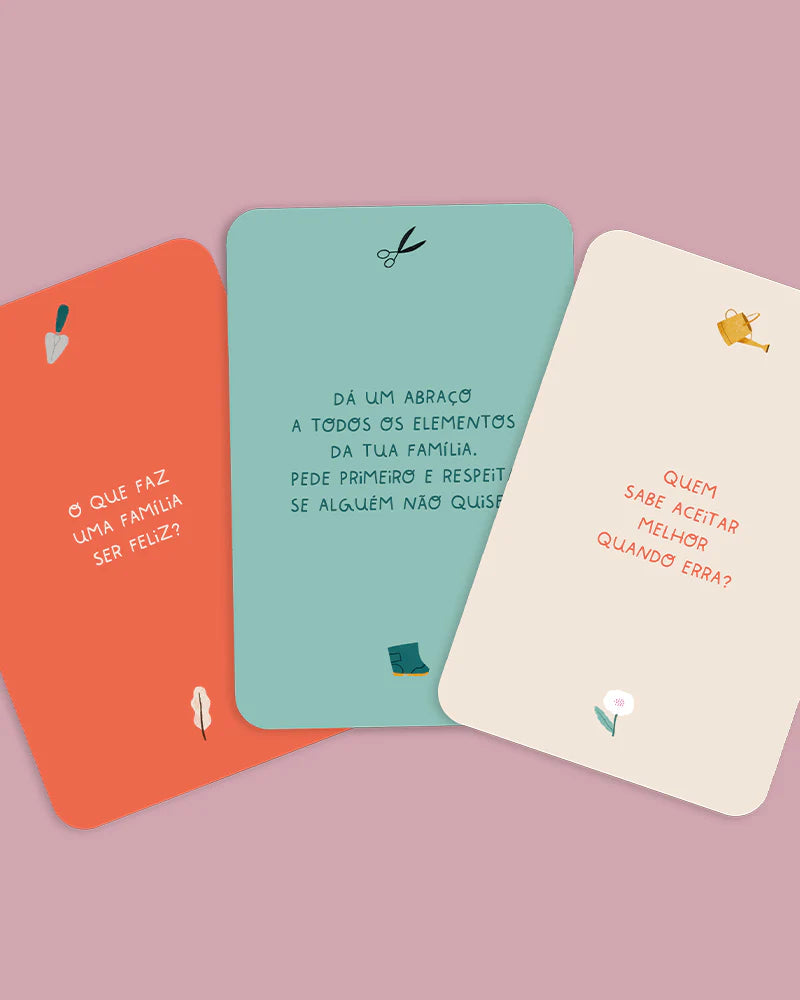 Três cartas do kit "Famílias Felizes" lado a lado, com exemplos de perguntas e desafios como "O que faz uma família ser feliz?" e "Dá um abraço".