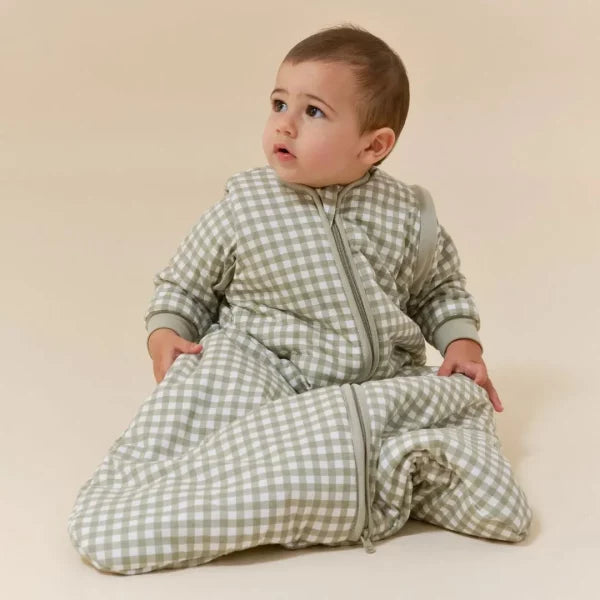 Bebé a usar o saco de dormir MolisandCo TOG 2.5 sem pés Mint Tea com mangas, sentado e a olhar para cima.