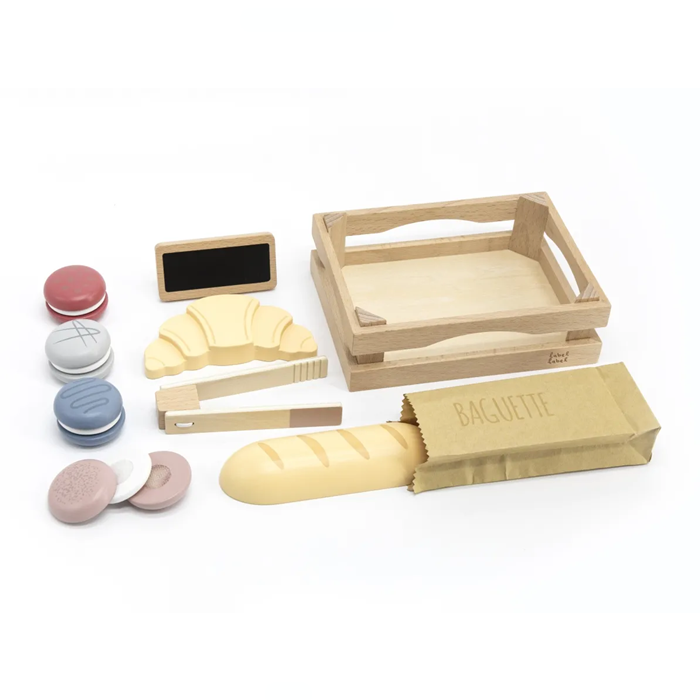 Todos os componentes do conjunto de brinquedo de madeira Label Label Pastelaria espalhados sobre fundo branco.