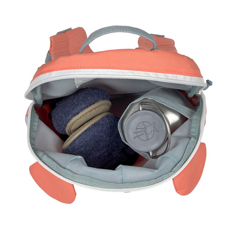 Interior da mochila coral preenchida com um par de pantufas azuis e uma garrafa de metal, mostrando a capacidade de arrumação.