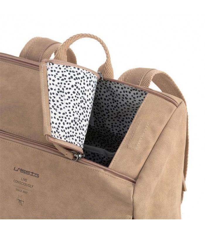 Detalhe do fecho superior da mochila Lassig aberto, revelando o forro interior com padrão de bolinhas pretas.