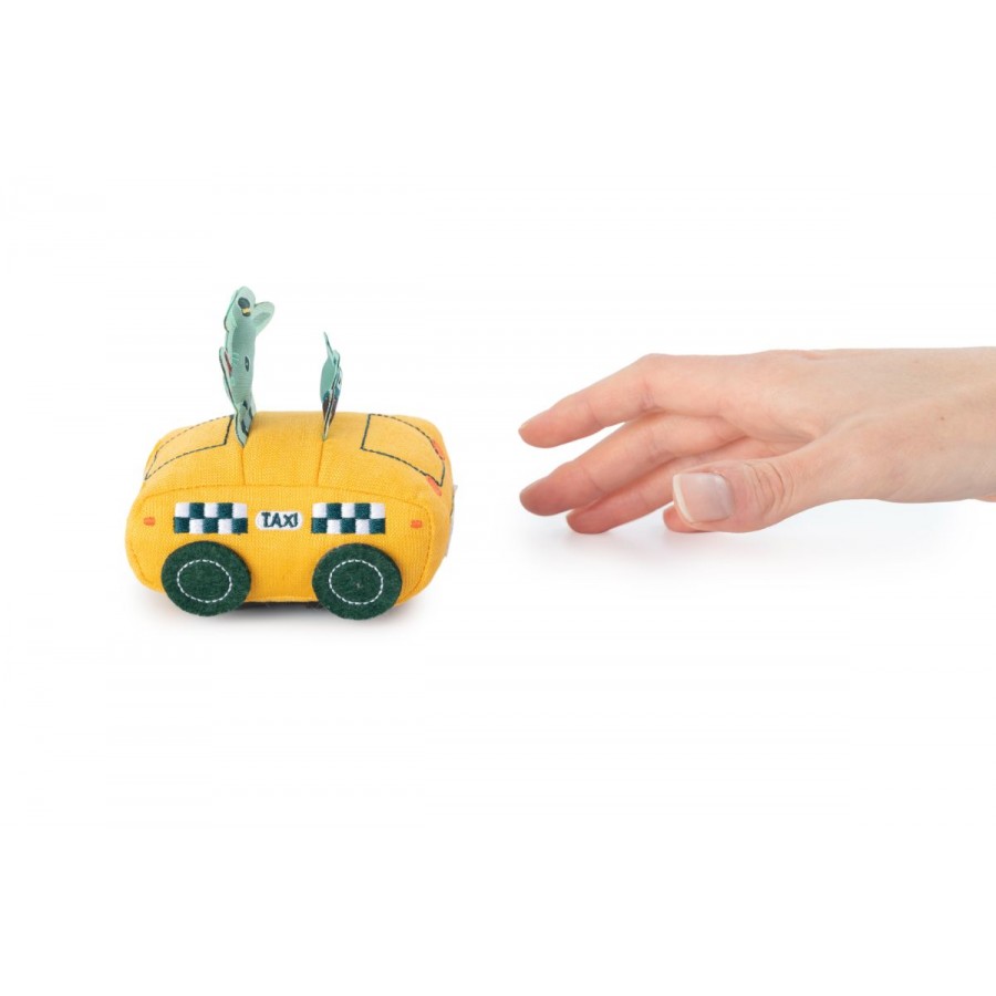 Mão alcançando carrinho de tecido Lilliputiens amarelo taxi. Ilustra mecanismo puxa-e-solta para bebé.