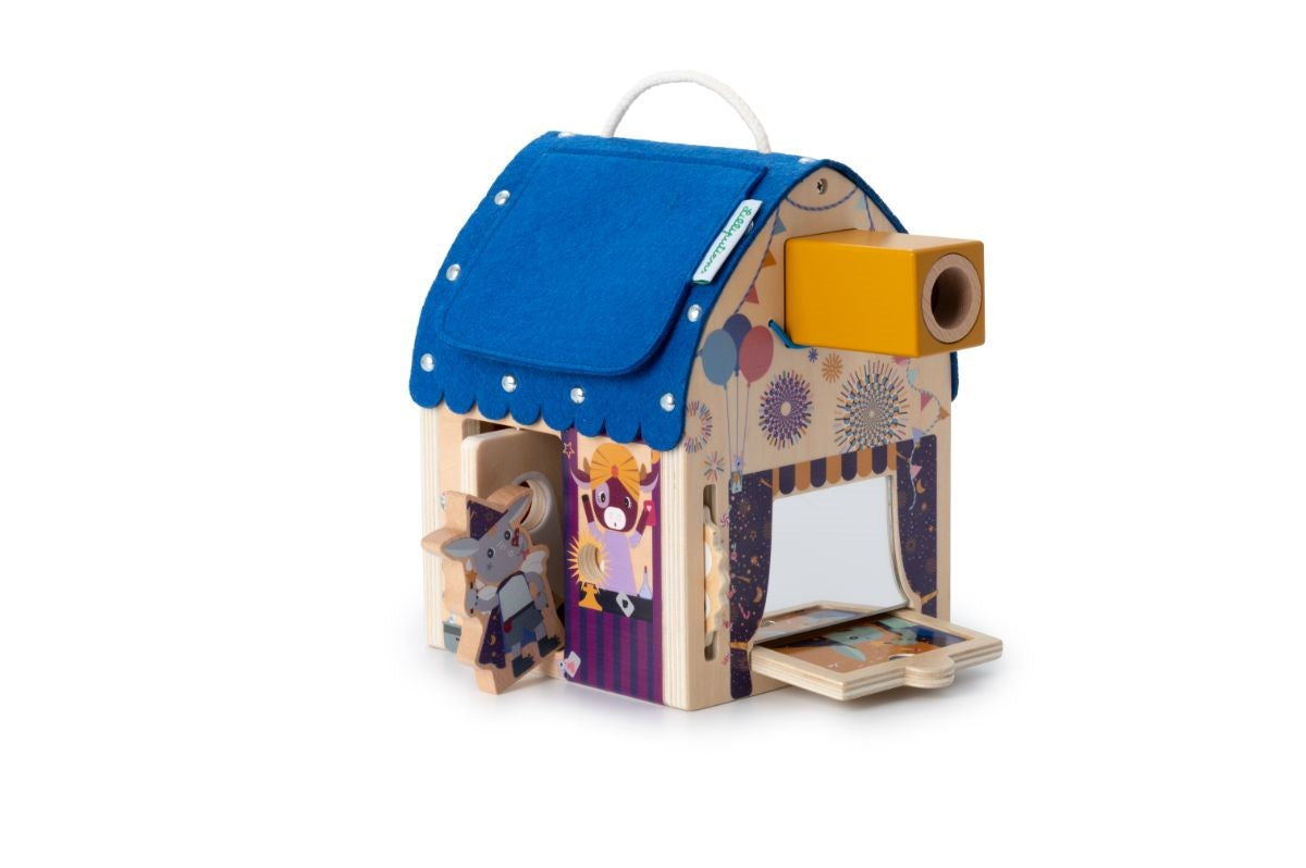 Casa do mágico Lilliputiens com um acessório de projeção amarelo encaixado no topo, perto do palco de teatro.