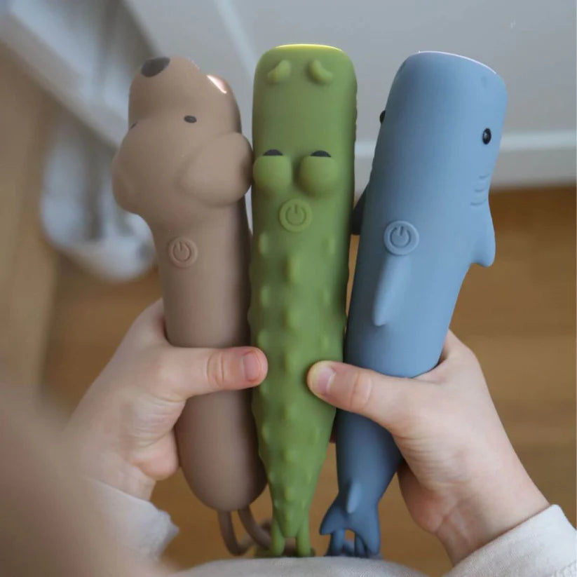 Mãos a segurar três lanternas Rabbit & Friends em silicone: urso, crocodilo verde e tubarão azul.