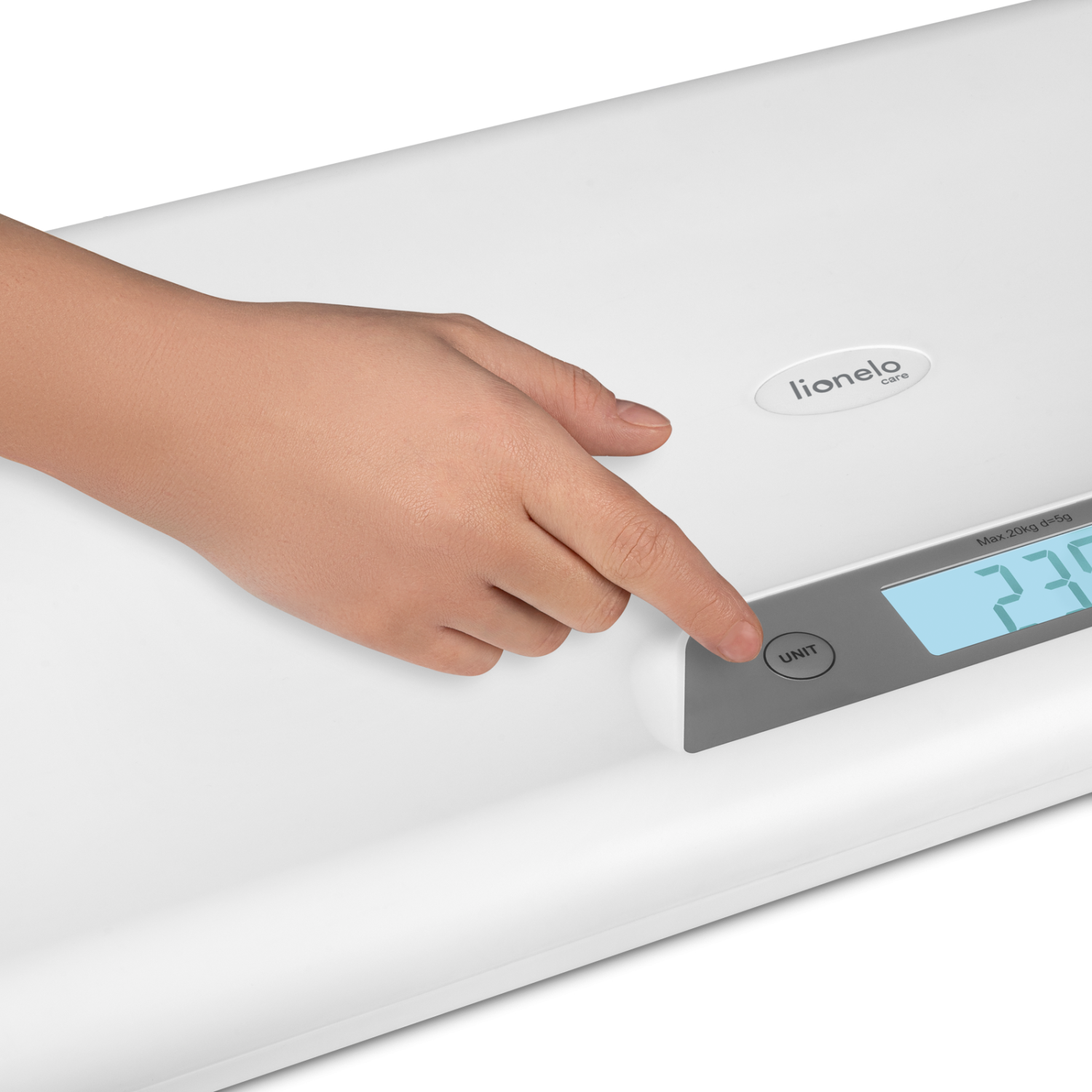Detalhe da mão de um adulto a pressionar o botão "UNIT" na balança Lionelo, mostrando o ecrã digital com a leitura de peso.