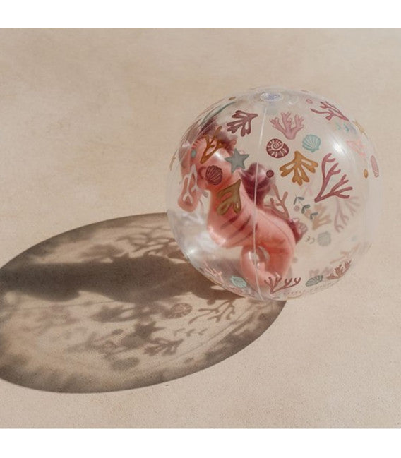 Detalhe da Bola de Praia 3D Little Dutch com tema marinho, com um cavalo-marinho 3D, projetando uma sombra complexa na superfície bege.