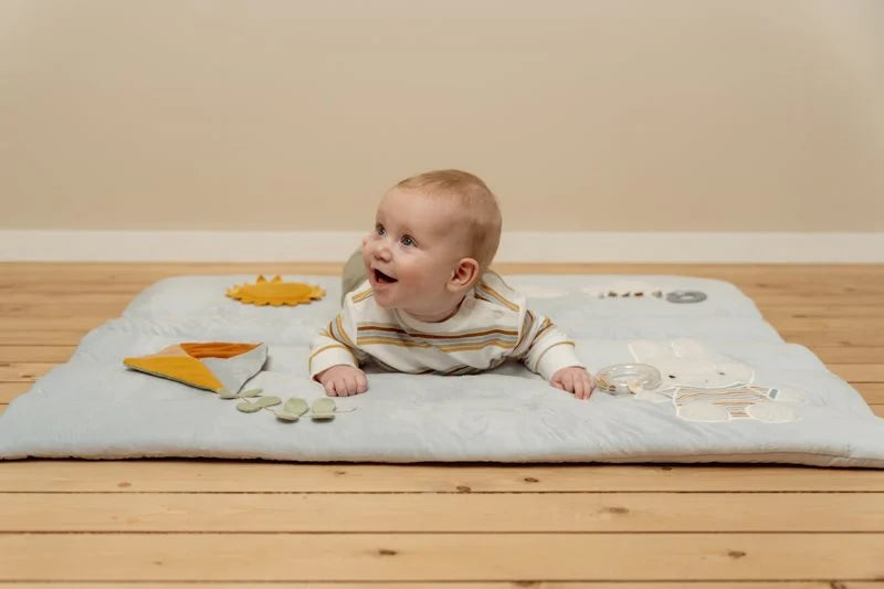Bebé deitado de barriga para baixo no tapete de atividades Little Dutch Sunny Stripes.