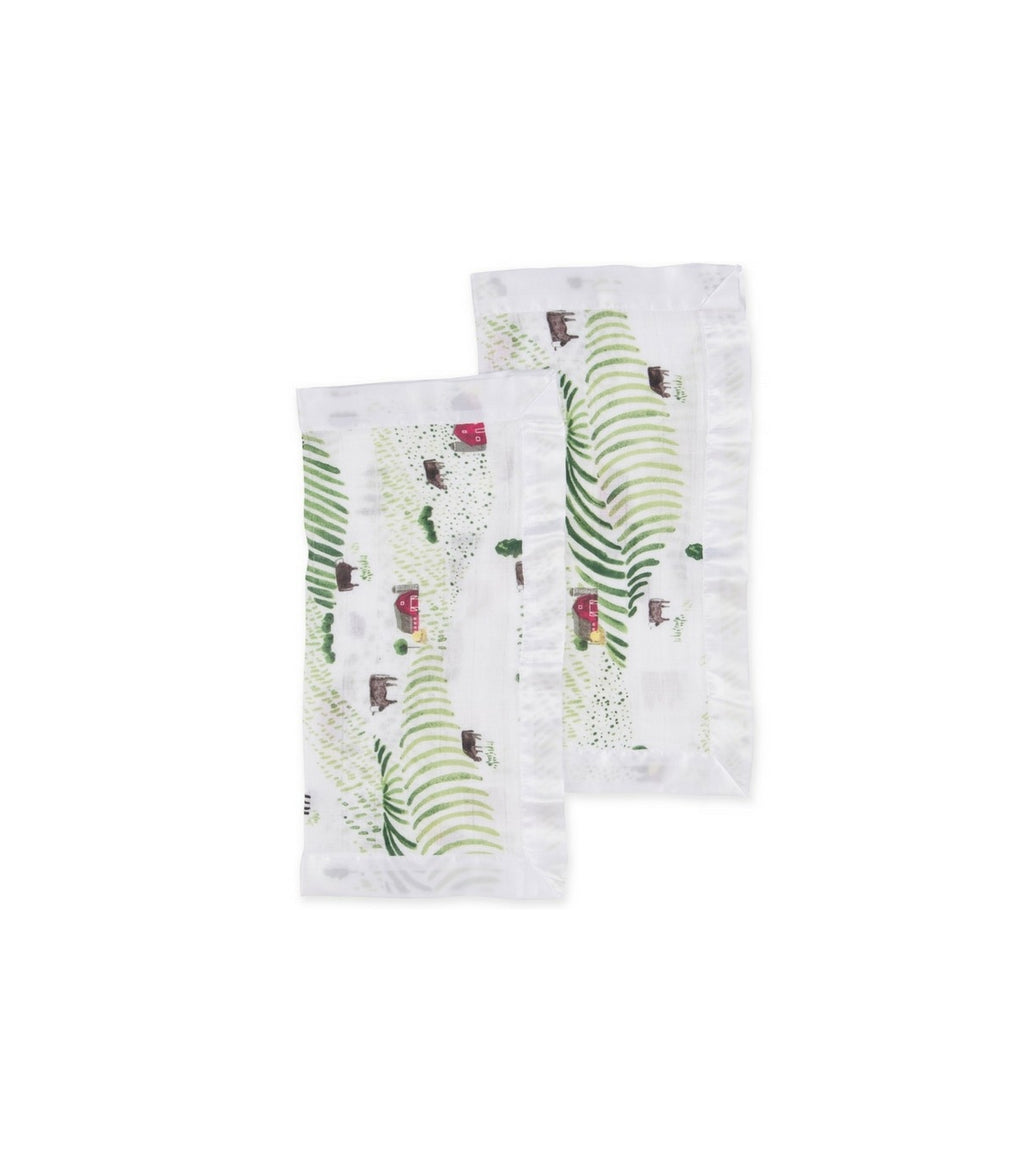 Imagem de estilo de vida: Fralda muselina Little Unicorn Rolling Hills usada como pano de ombro sobre o ombro de um bebé.