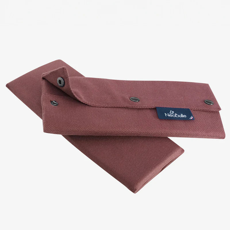 Par de protetores de alças Neobulle em cor bordeaux/rosa escuro, dobrados e fechados com botões de pressão, exibindo a etiqueta azul da marca.
