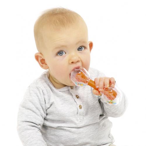 Bebé a morder a crista de silicone flexível da caixa de música tucano, que serve como mordedor, enquanto segura o instrumento.
