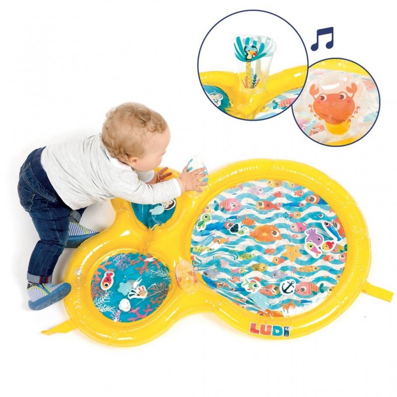 Bebé a brincar e apoiar-se no Ludi Tapete de água Insuflável, interagindo com o jogo sensorial.