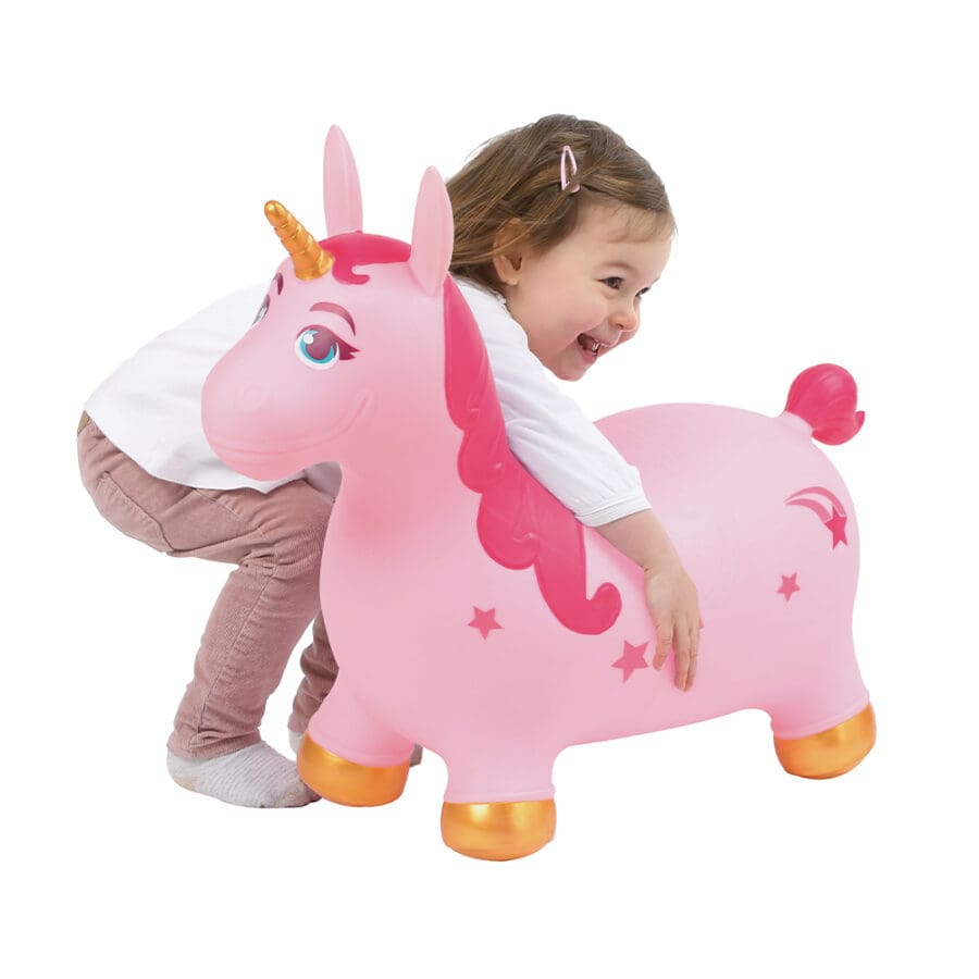 Criança pequena a abraçar carinhosamente o unicórnio insuflável cor-de-rosa da Ludi, num fundo branco.