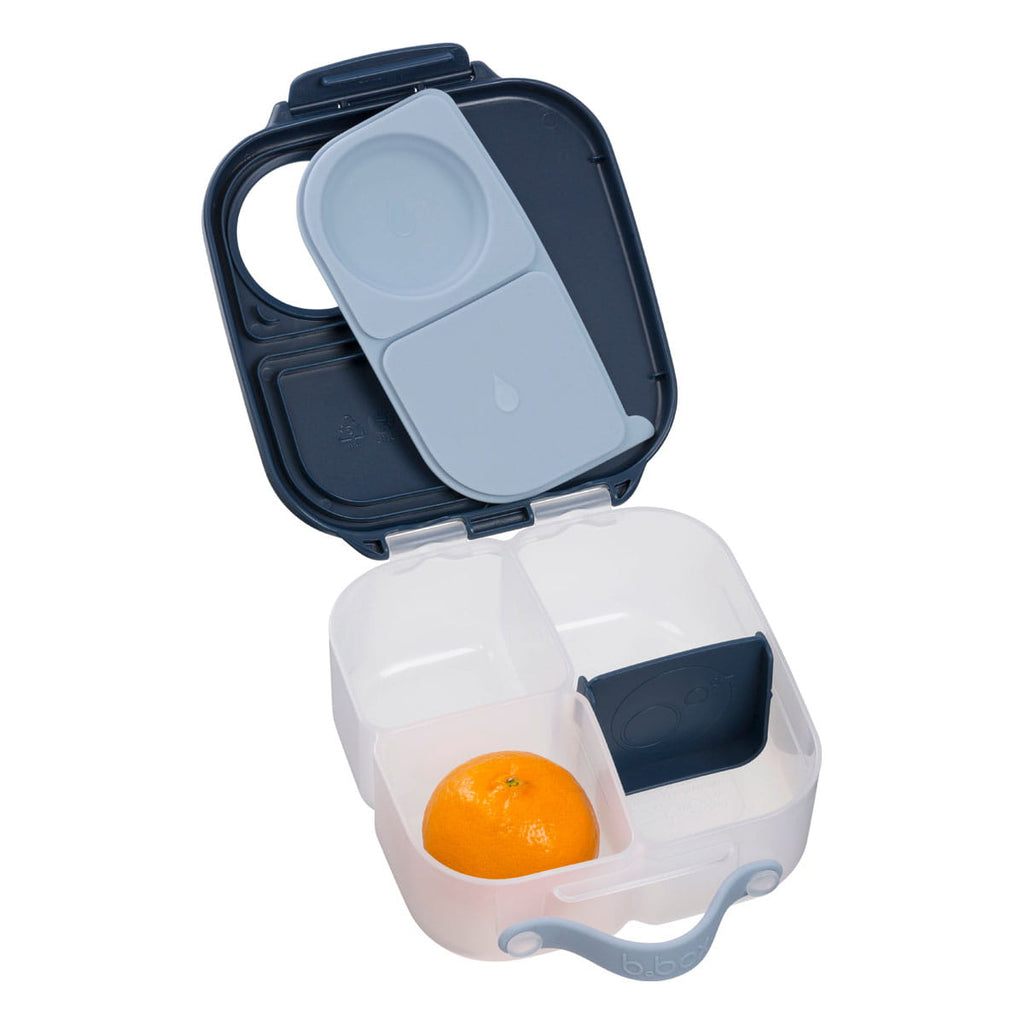 Lunchbox mini b.box aberto com uma tangerina numa das secções, ilustrando o uso para frutas.