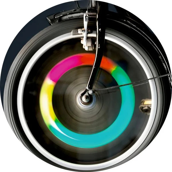 Efeito luminoso colorido da luz LED instalada numa roda de bicicleta em movimento.