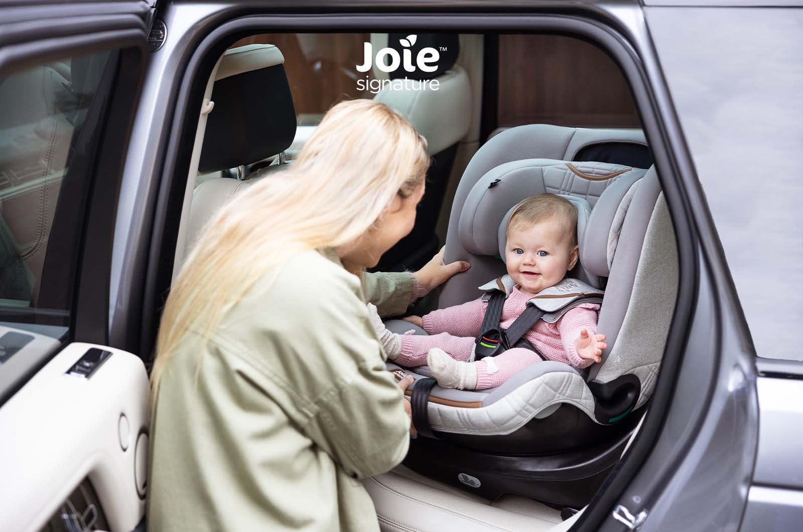 Mãe a colocar o bebé na cadeira auto Joie i-Spin XL Signature no carro, mostrando a facilidade de acesso devido à rotação.