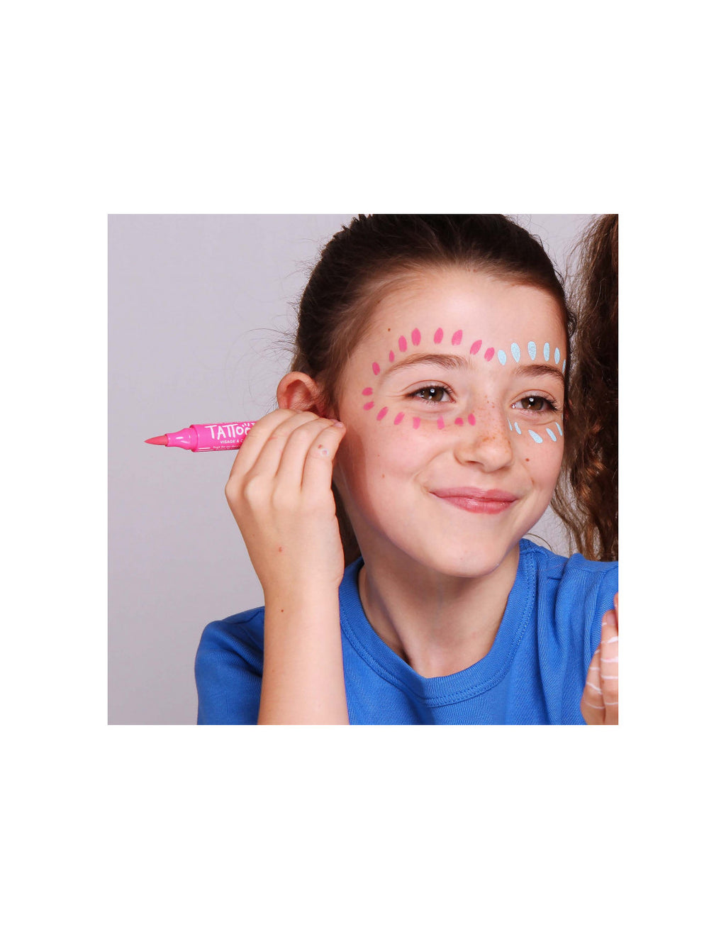 Criança a aplicar padrões cor-de-rosa e azul ao redor dos olhos com marcador de tatuagem Nailmatic.