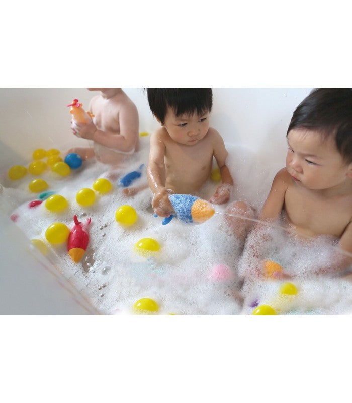 Brinquedo de banho foguetão Marcus & Marcus em silicone azul e amarelo, ideal para bebés a partir dos 0 meses.