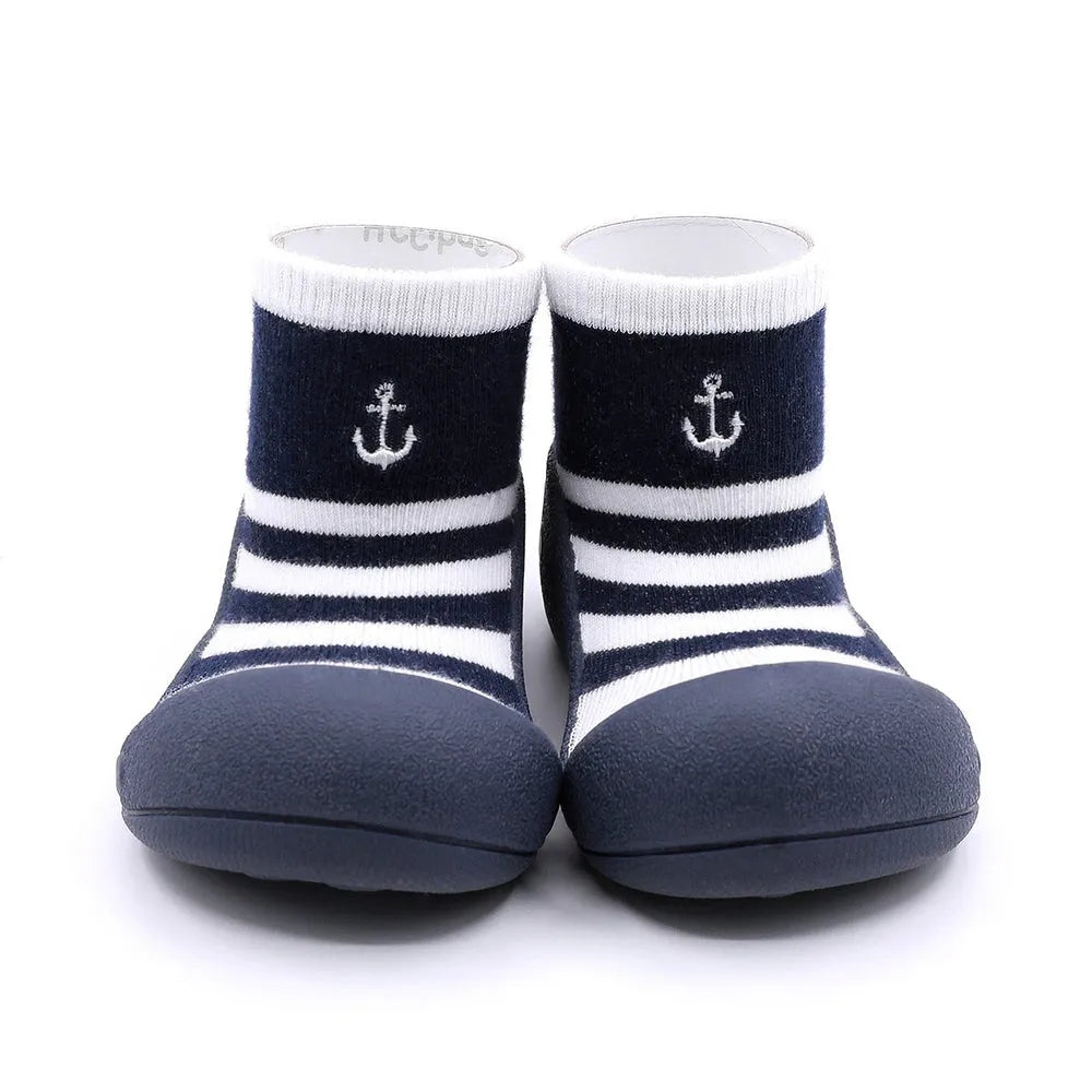 Marine Boy Navy com riscas em azul marinho e branco, detalhe de âncora bordada. Calçado barefoot para bebé com sola flexível e antiderrapante.