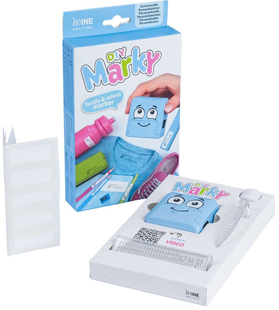 Kit de carimbo MARKY DIY (azul) aberto, mostrando o carimbo, a fita têxtil e a caixa com exemplos de aplicação em têxteis e material escolar.