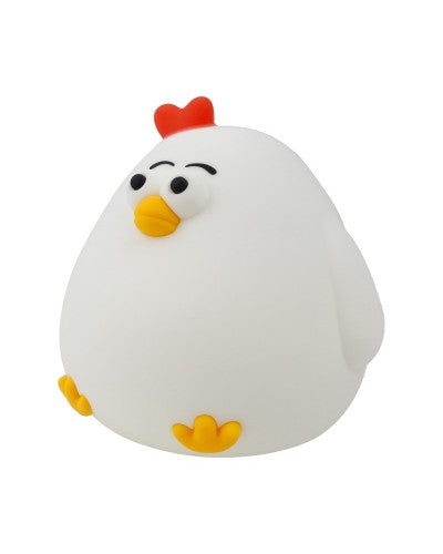 Close-up de uma luz noturna em forma de galinha de silicone branca, com crista vermelha e bico laranja, vista frontal.