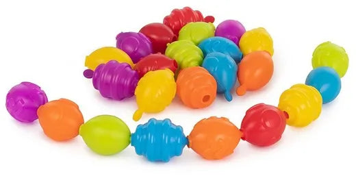 Várias contas Miniland Maxichain em diferentes cores (roxo, vermelho, verde, azul, laranja, amarelo) dispostas em semicírculo, algumas já encaixadas, mostrando a variedade de formas e a capacidade de ligação.