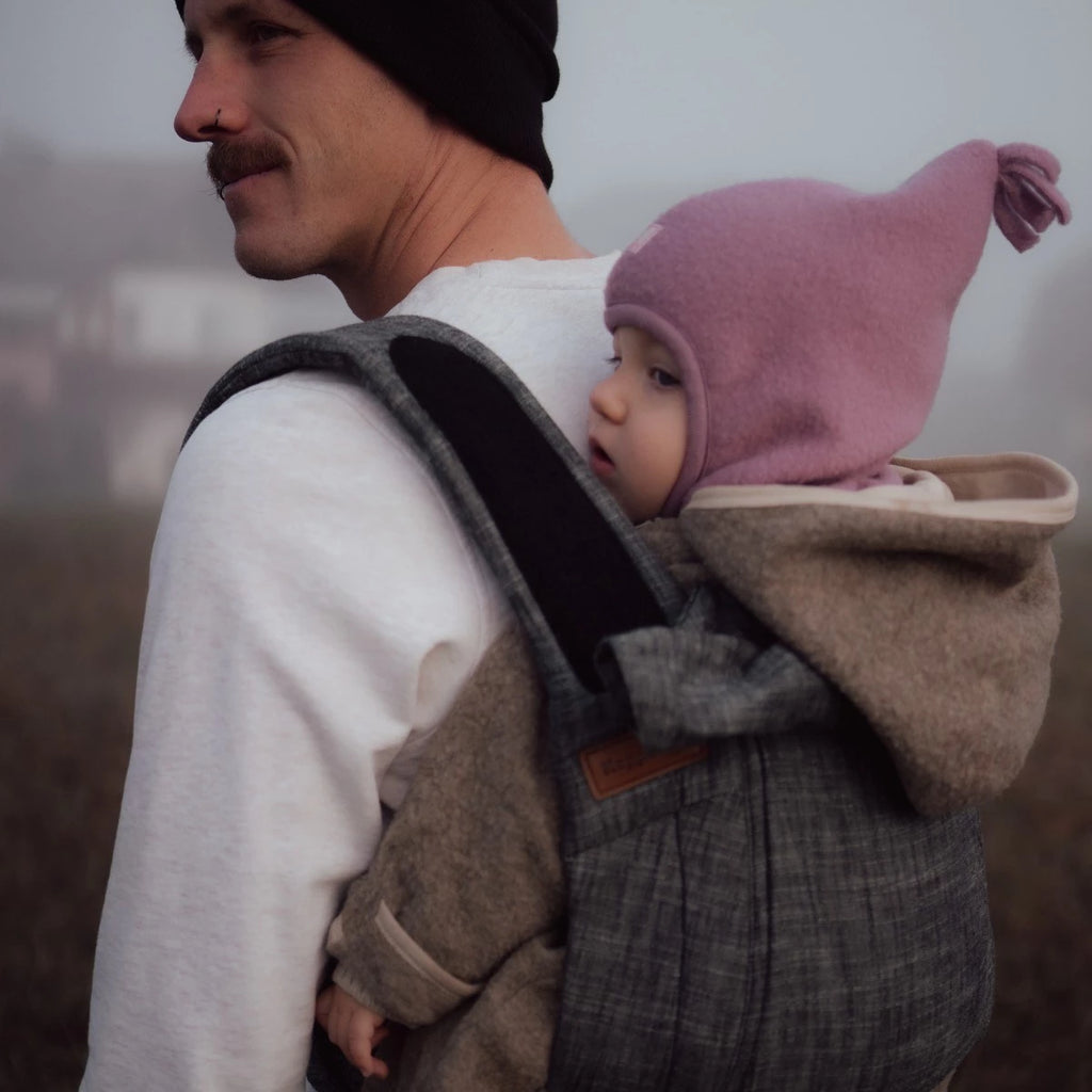 Close-up do tecido 'B.Pure Denim Black' do porta-bebés Hoppediz, destacando a textura respirável e a cor preta/azul escura.