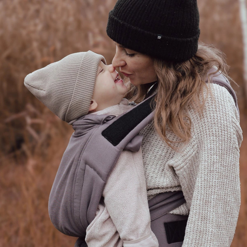 Bebé transportado na posição frontal com o Mei Tai Hoppediz Bondolino B.Pure, demonstrando a posição ergonómica em "M".