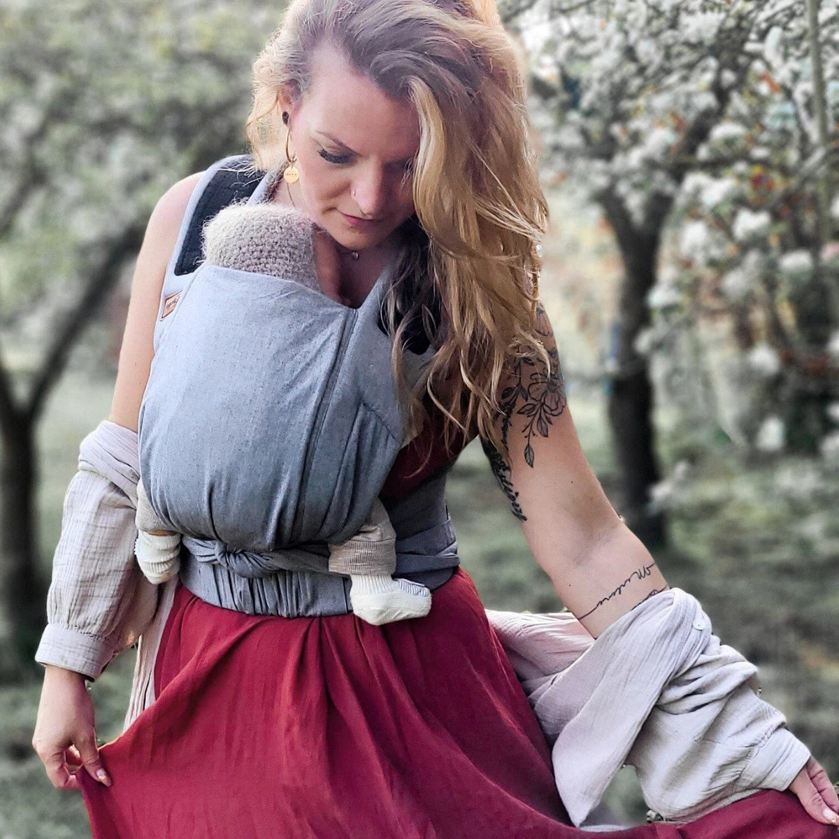 Vista traseira do porta-bebés Hoppediz Bondolino cinzento, ilustrando a posição nas costas, ideal para bebés mais velhos e maior conforto do portador.