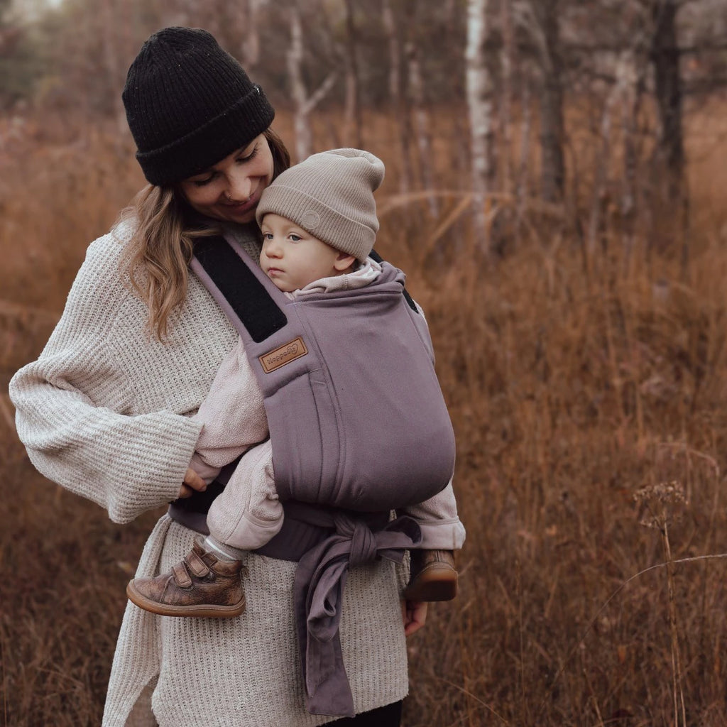 Vista traseira do Mei Tai Hoppediz Bondolino, mostrando o bebé seguro nas costas do cuidador, ideal para pesos até 20 kg.