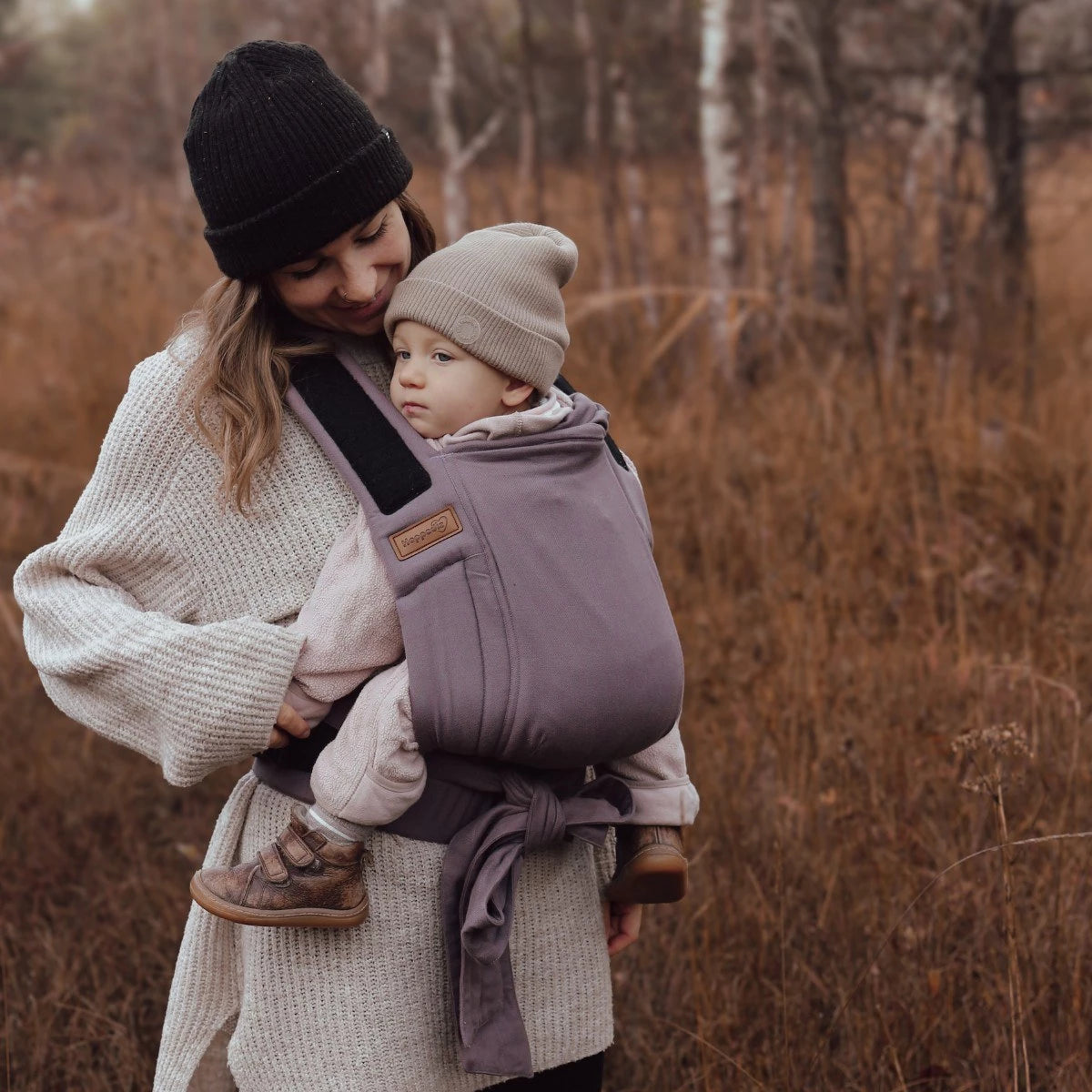 Vista traseira do Mei Tai Hoppediz Bondolino, mostrando o bebé seguro nas costas do cuidador, ideal para pesos até 20 kg.
