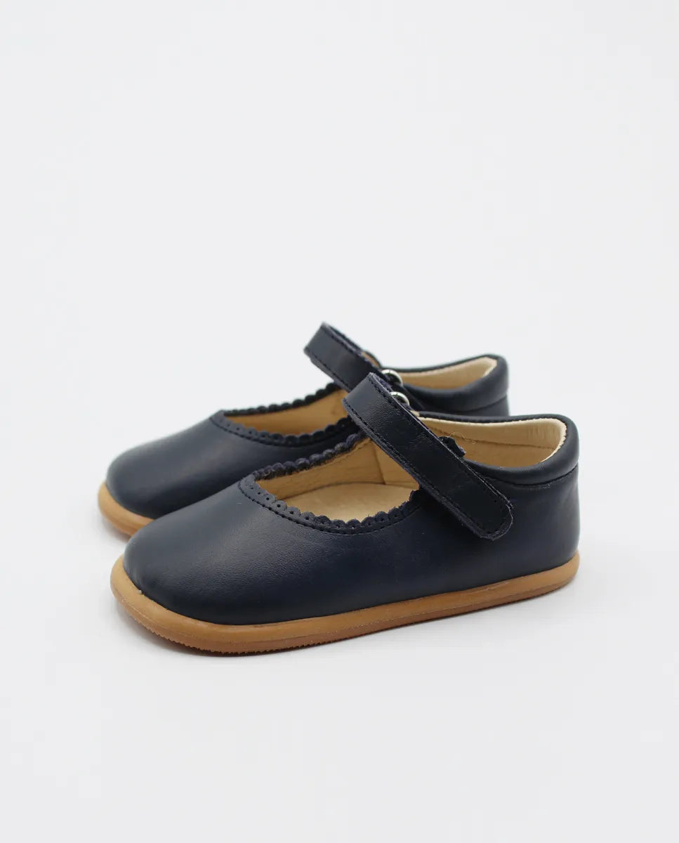  Merceditas Chloe em pele azul-marinho, com fecho em Velcro e sola de borracha antiderrapante, vista lateral de par completo.