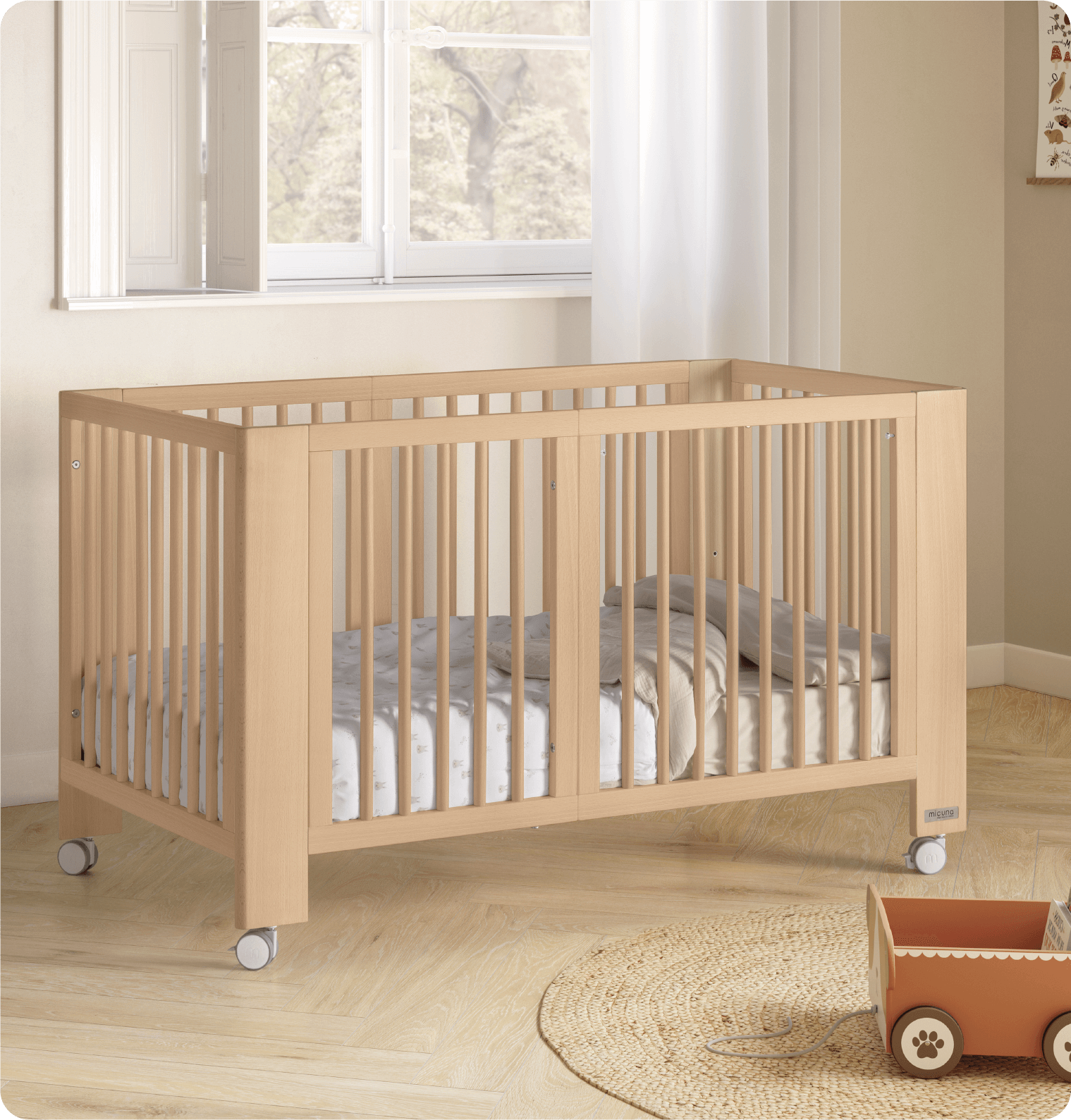 Berço Micuna Converbaby em cor madeira natural, na configuração de berço 140x70 cm, com roupa de cama, num quarto luminoso.