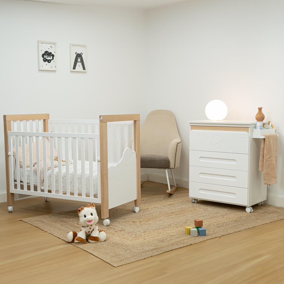 Quarto de bebé moderno com o mini-berço Micuna DolceMagic 120x60, em branco e madeira, e cómoda a condizer. Ambiente claro e acolhedor.