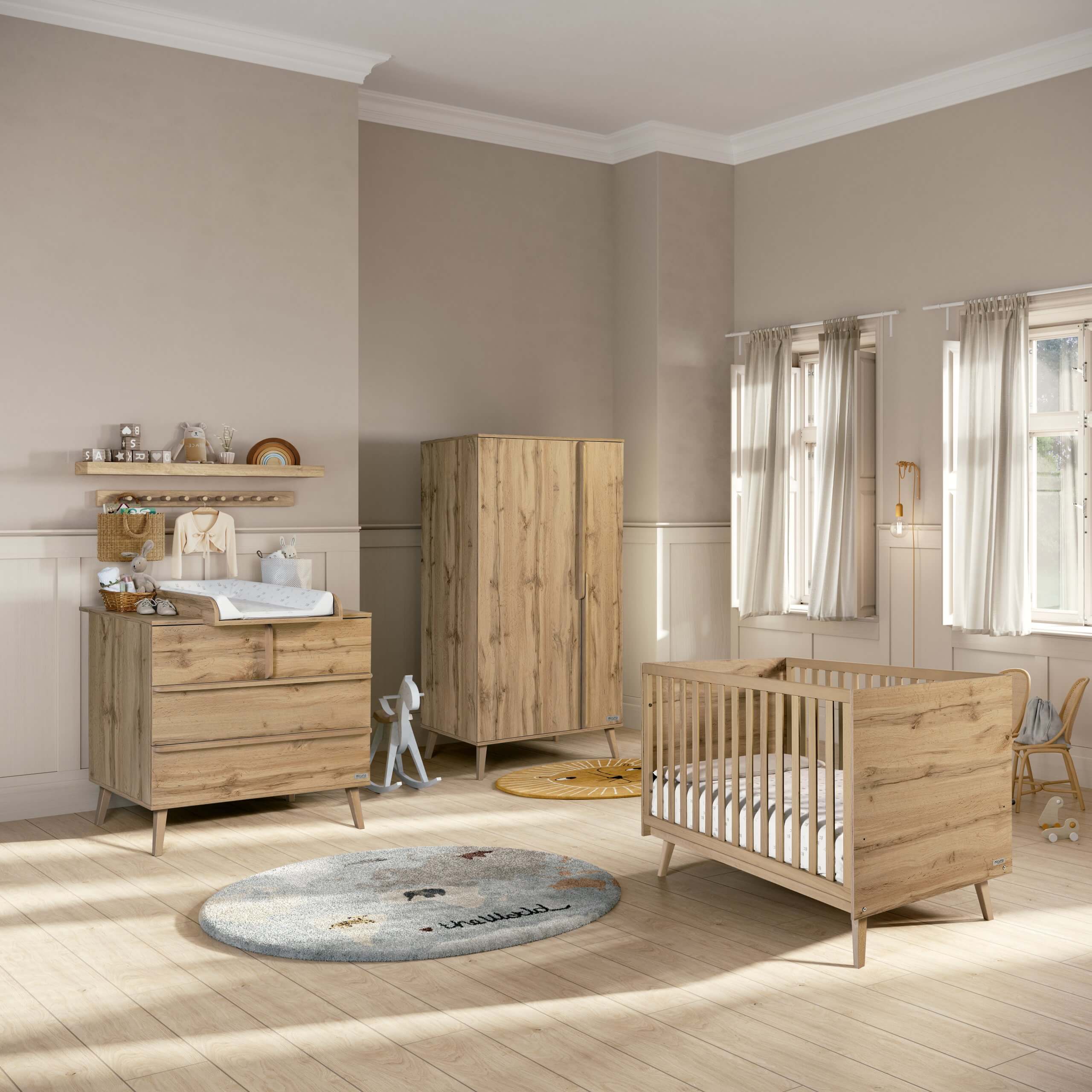 Ambiente de quarto de bebé com armário Micuna Martha em carvalho escuro, berço e cómoda a condizer, decoração neutra.