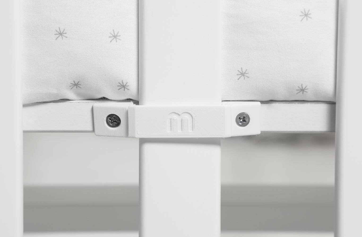 Detalhe do logótipo Micuna em relevo no suporte lateral do mini-berço You and Me Plus.