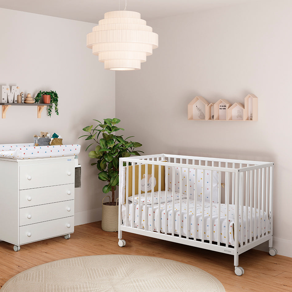 Micuna Mountain Berço 120x60 branco num quarto de bebé moderno, com trocador e decoração.