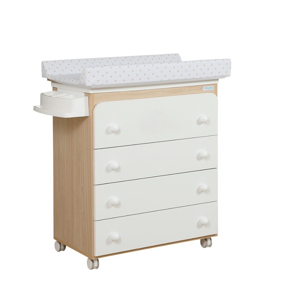 Móvel Micuna com estrutura em madeira clara, 4 gavetas brancas e muda-fraldas com padrão de bolinhas bege.