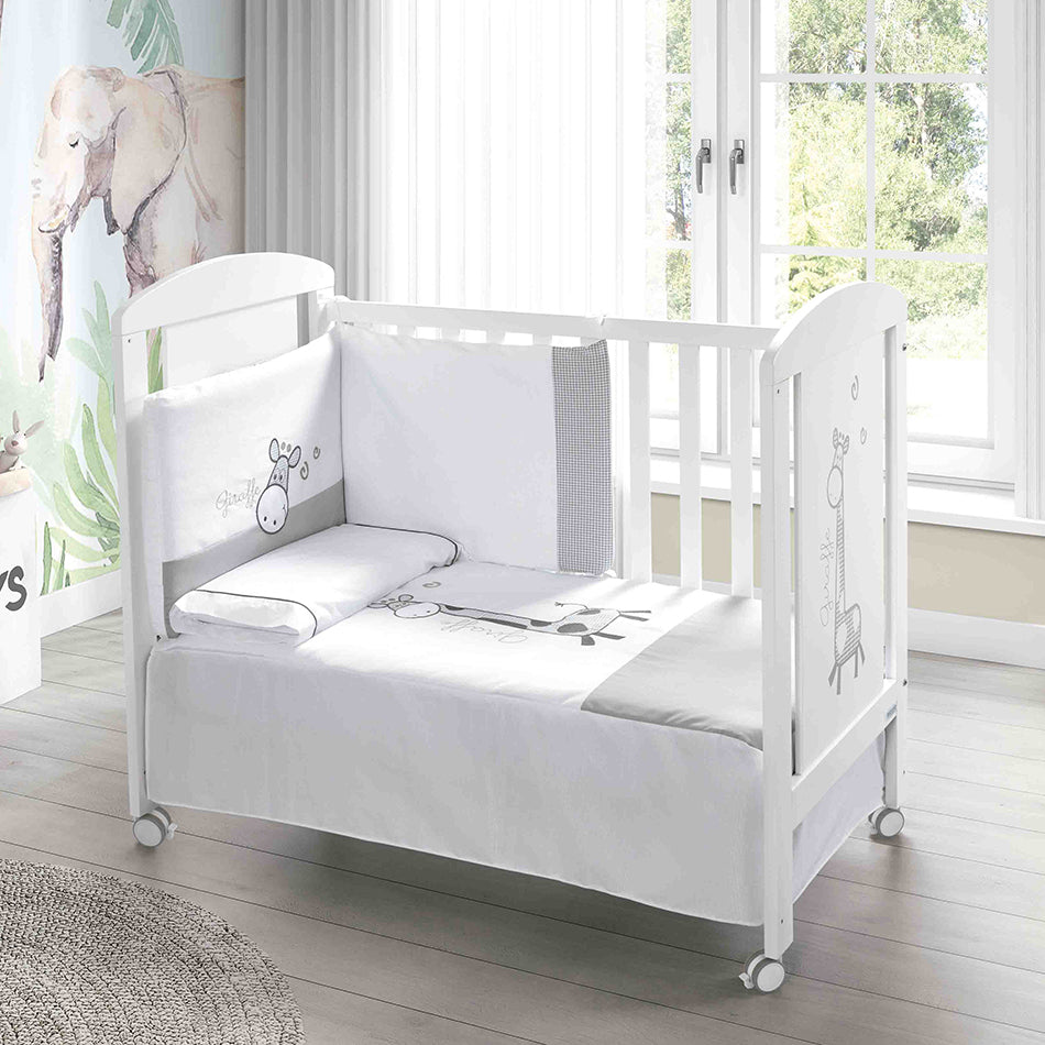 Berço Micuna Sabana 120x60 com roupa de cama e protetores com tema de girafa, num quarto de bebé.