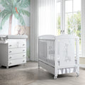 Berço Micuna Sabana 120x60 branco com girafa, num quarto de bebé com cômoda e decoração de selva.